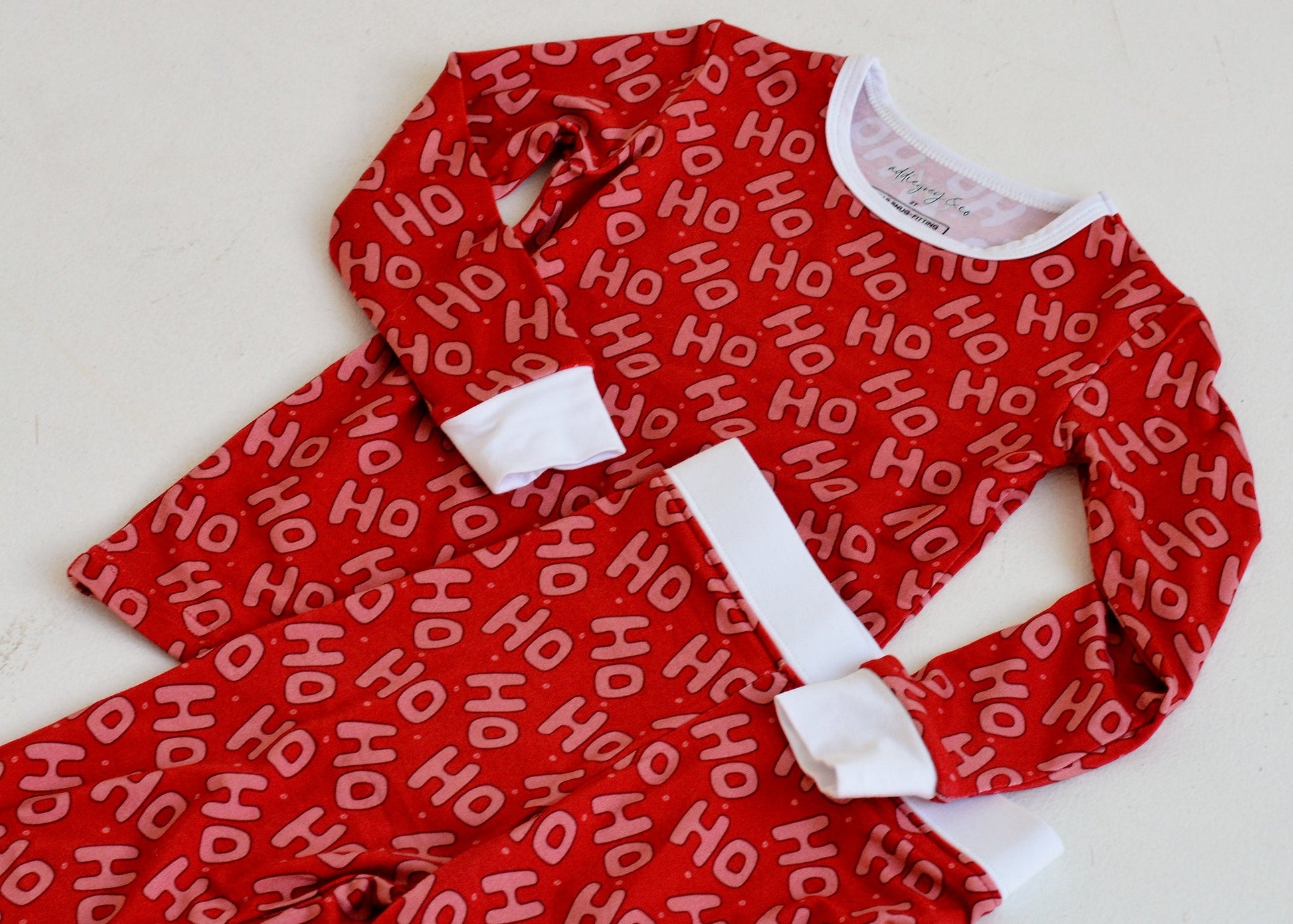 Kids wearing red Ho Ho Ho bamboo Christmas pajamas — matching holiday sleepwear for siblings | AddieGrey & Co